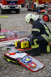 Person auf einer Trage, die von der Feuerwehr betreut wird